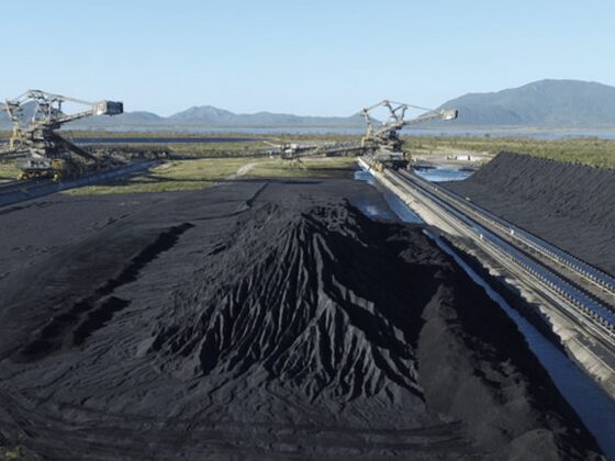Large coal stockpiles with stacker and conveyor machinery.