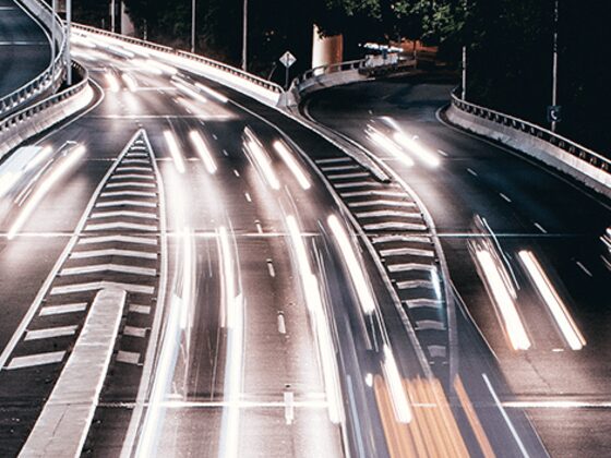 Traffic light trails along a highway at dusk.